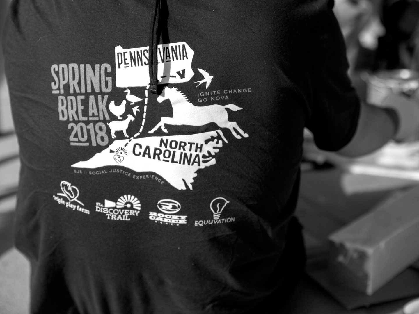 Black-and-white photo of the service break trip T-shirt worn by the Villanova students.