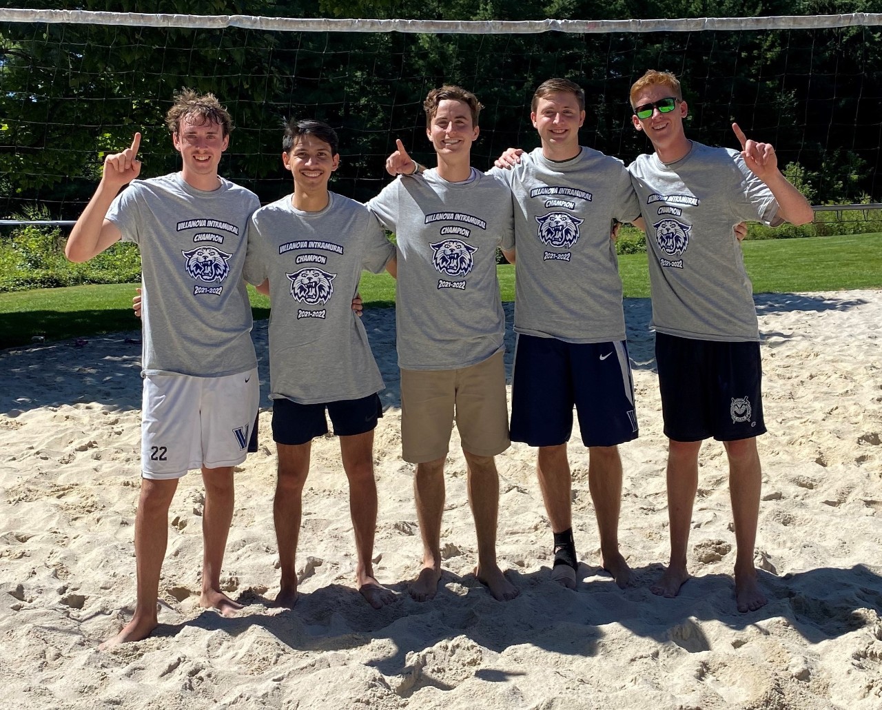 Male students posing for sand volleyball champion photo