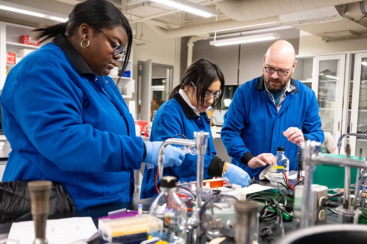 students and faculty working in a science lab students and faculty working in a science lab