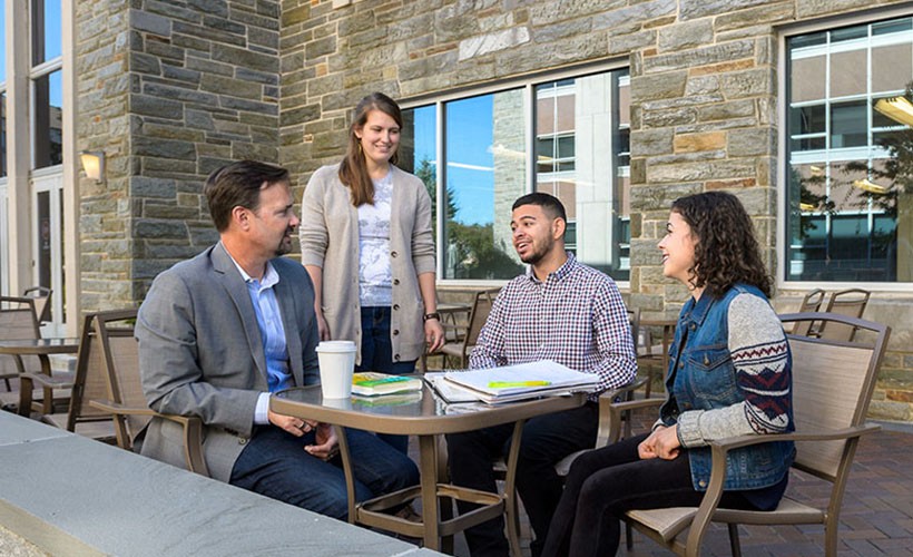 Students meet with professor outdoors Students outdoors