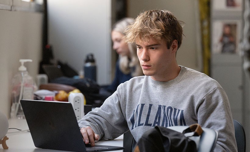 Male student viewing laptop