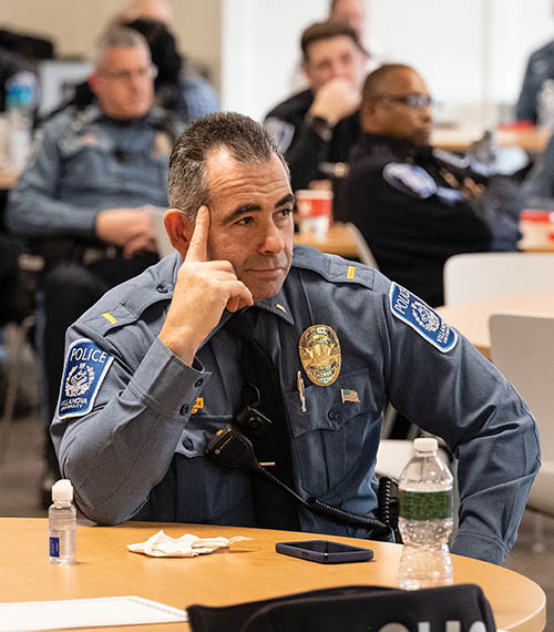 A public safety officer listening to someone give a speech