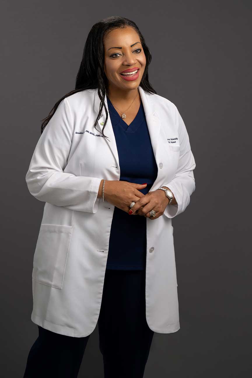 Lt. Cmdr. Akeeka Davis standing in her white Villanova lab coat and blue nursing scrubs