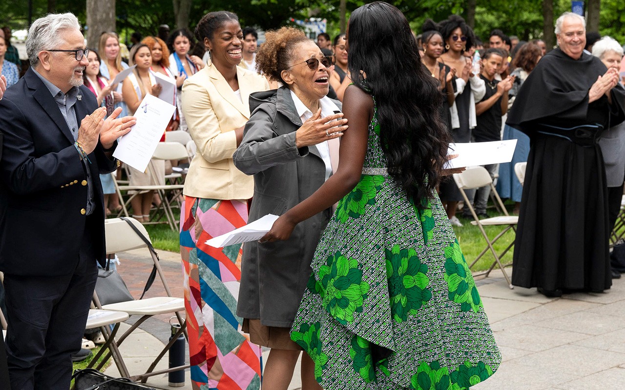 Teresa Nance moves to embrace a younger woman who is elegantly dressed.