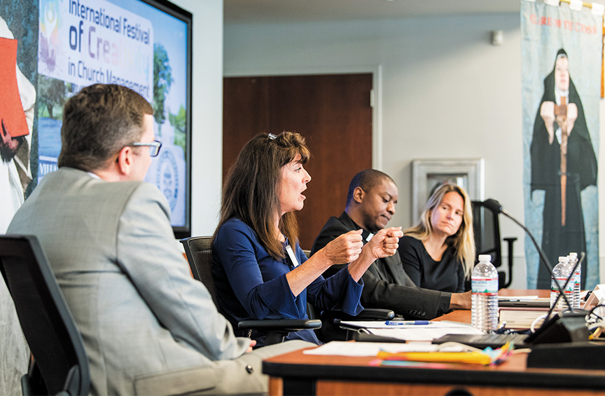 four Church Management research fellows sit together at a conference table