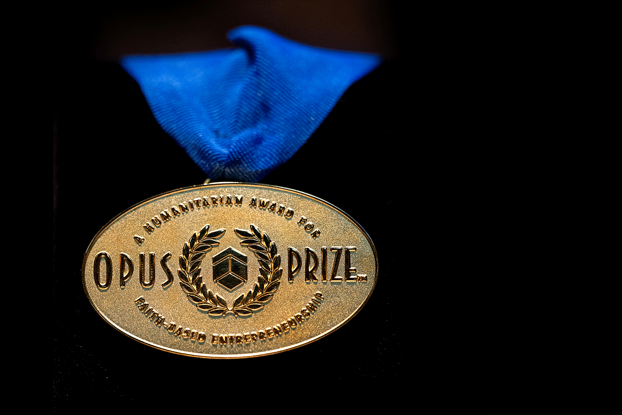 The gold Opus Prize medal hangs on a blue ribbon