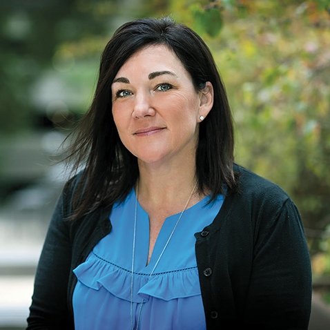 portrait of the Rev. John P. Stack dressed casually in a classroom